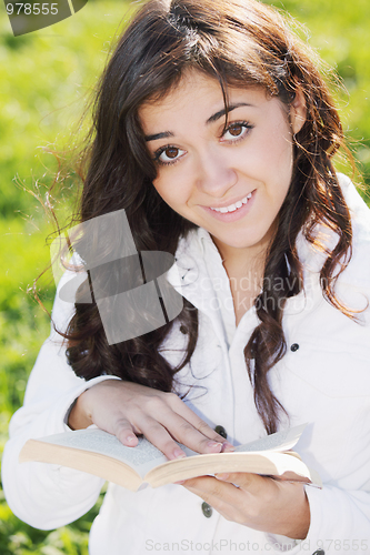 Image of Young smiling brunette in white with book