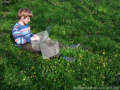 Image of child with notebook sit green grass