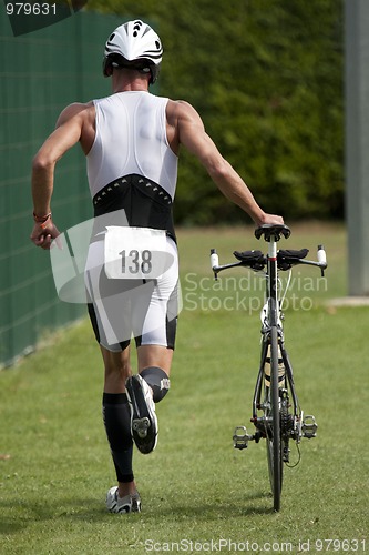 Image of Triathlete pushing his bike