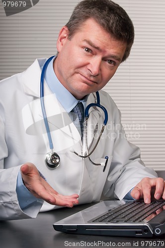 Image of Friendly doctor looks at camera and gestures