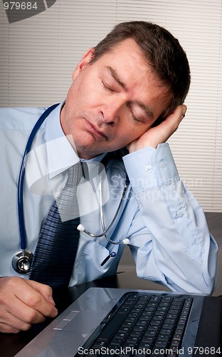 Image of Tired doctor sleeps at desk