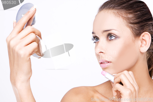 Image of Beautiful woman applying lipstick