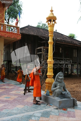 Image of Monks fixing a lamp