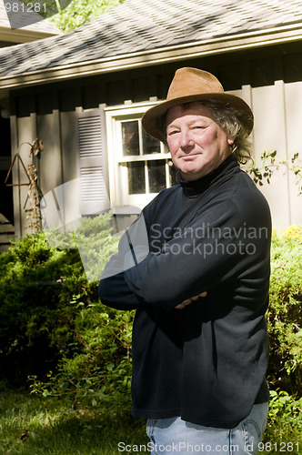 Image of middle age senior man with fashionable hat in yard