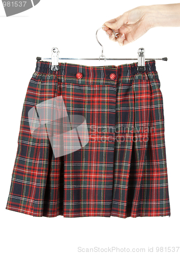 Image of Feminine hand keeps plaid skirt