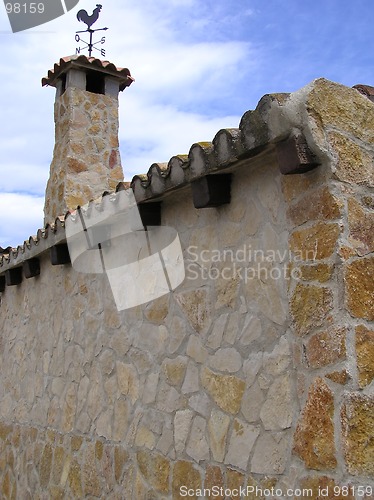 Image of stone chimney with weathervane