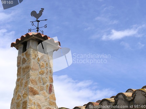 Image of stone chimney with weathervane