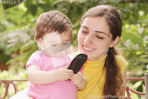 Image of Baby girl looking at phone receiver