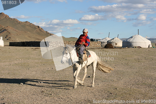 Image of Mongolian boy racing on a horse