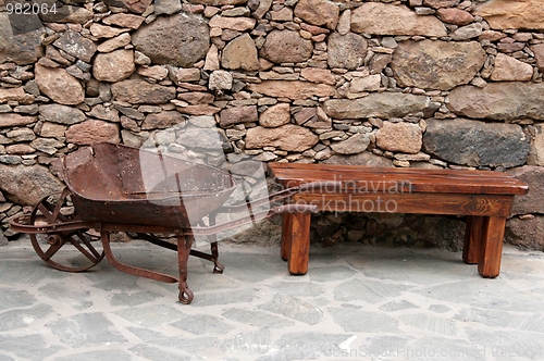 Image of Old wheelbarrow and bench