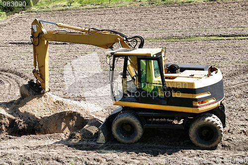 Image of Photo of a working excavator in the countryside 