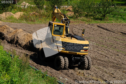 Image of Photo of a working excavator in the countryside 