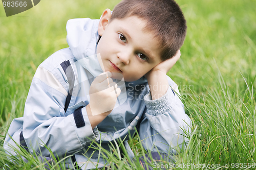 Image of Thoughtoful little boy in grass