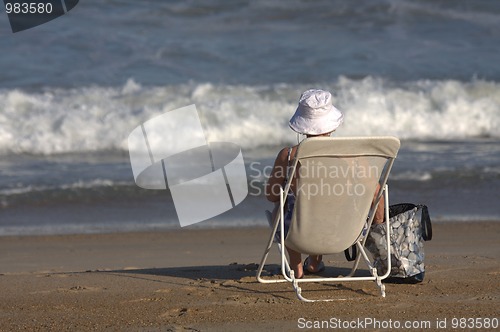 Image of old lady sitting in a chair on the beach