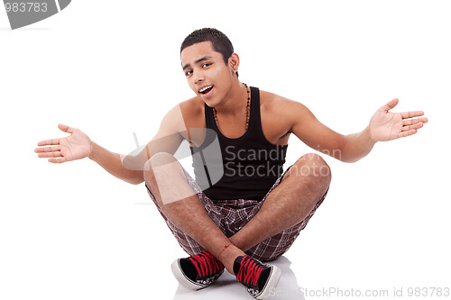 Image of young man with open arms, sitting on floor