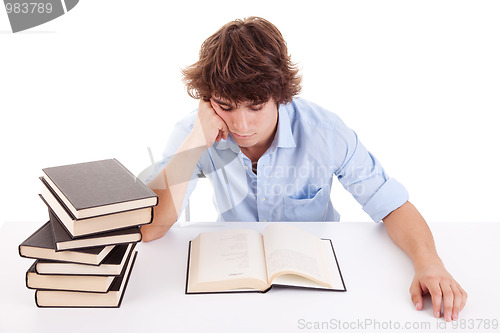 Image of cute boy studying and reading a book on his desk