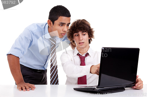 Image of Two young businessmen working together on a laptop
