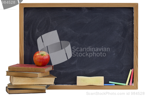 Image of blackboard with old textbooks and apple