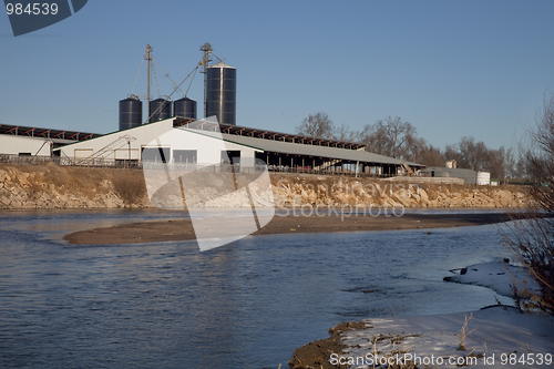 Image of cattle ranch buildings on river shore