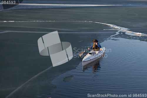 Image of canoe paddling on ice covered lake