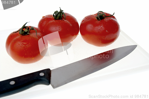 Image of Cutting board with a knife and tomato