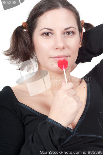 Image of Portrait of pretty woman in black eating candy