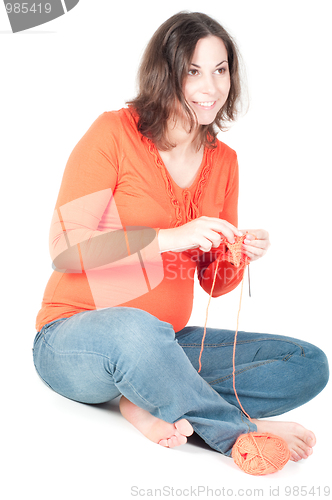 Image of Portrait of pretty pregnant woman knitting