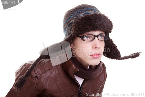 Image of Young boy looking serious, with winter clothes and hat in the wind