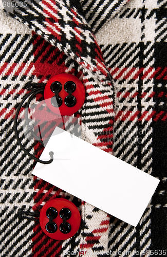 Image of Blank price tag on checked coat with red buttons