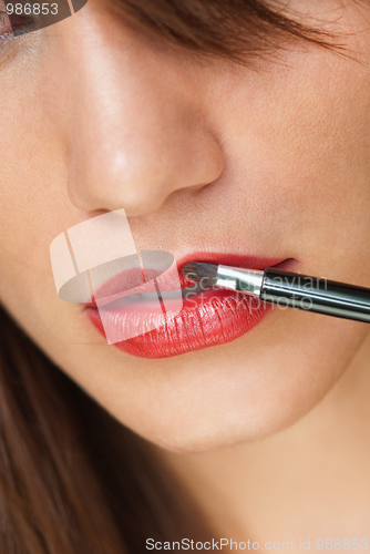 Image of Woman applying make up