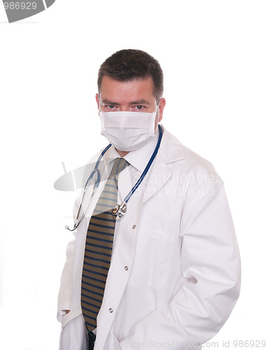 Image of Doctor with face mask looks intently at camera