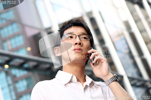 Image of casual asian businessman talking on his cell phone 