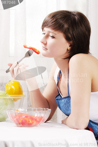 Image of Housewife eating fresh paprika salad