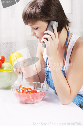 Image of Housewife talking on phone eating fresh salad