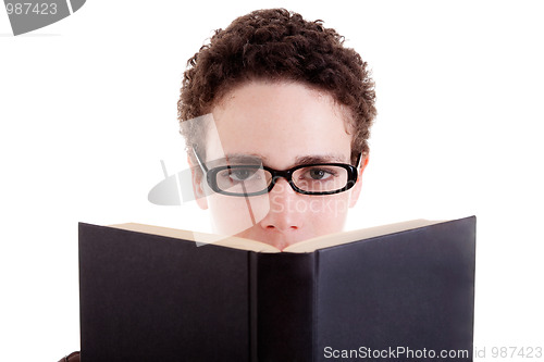 Image of Young man with glasses, peering over an open book