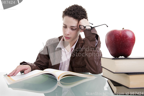 Image of cute boy studying and thinking, along with one on apple top of some books