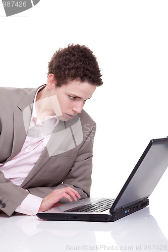 Image of Young man typing and looking at screen of laptop