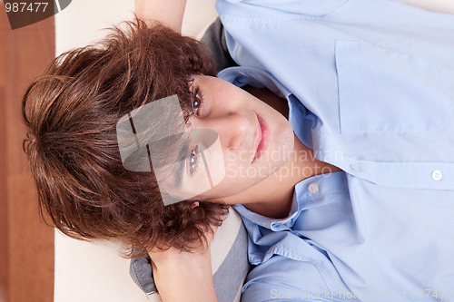 Image of young man, lying on the couch