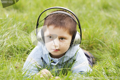 Image of Serious boy laying in grass