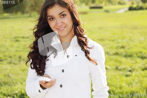 Image of Smiling brunette with white cellphone