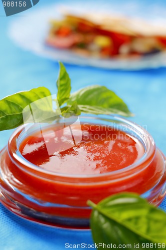 Image of Tomato sauce with basil leaves