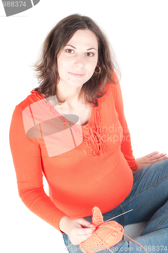 Image of Portrait of pretty pregnant woman knitting