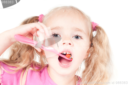 Image of Little cute girl in studio brushing teeth