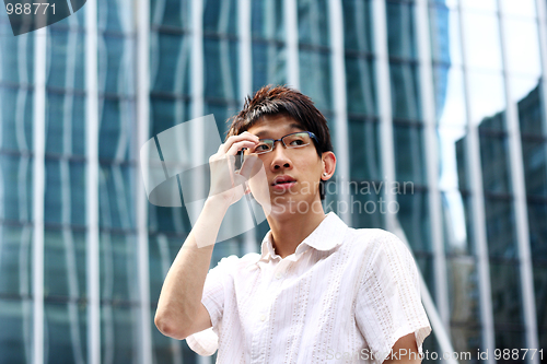 Image of asian businessman holding glasses