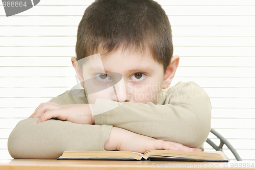 Image of Cute boy with book arms folded