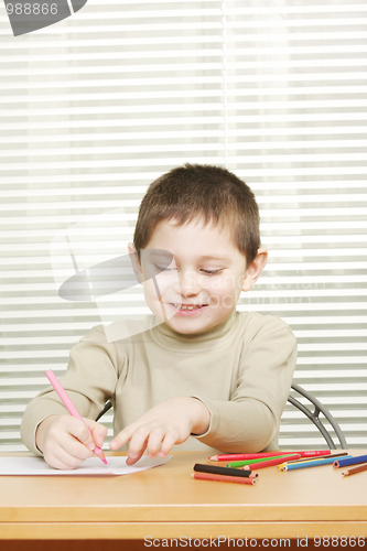 Image of Smiling boy drawing with crayon