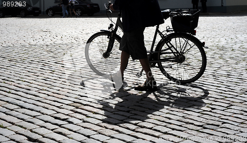 Image of Man walking his bicycle