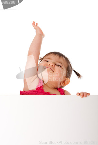 Image of Happy baby holding white board and reaching up
