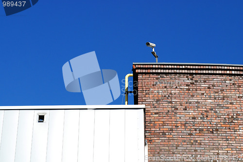 Image of Security camera against blue sky 