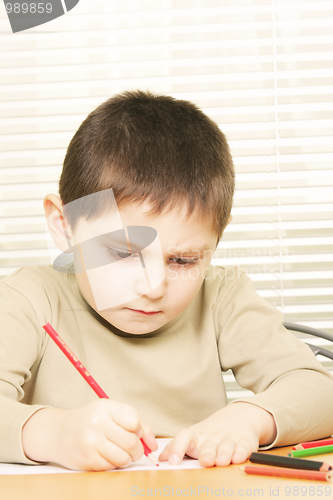 Image of Concentrated boy drawing with crayon